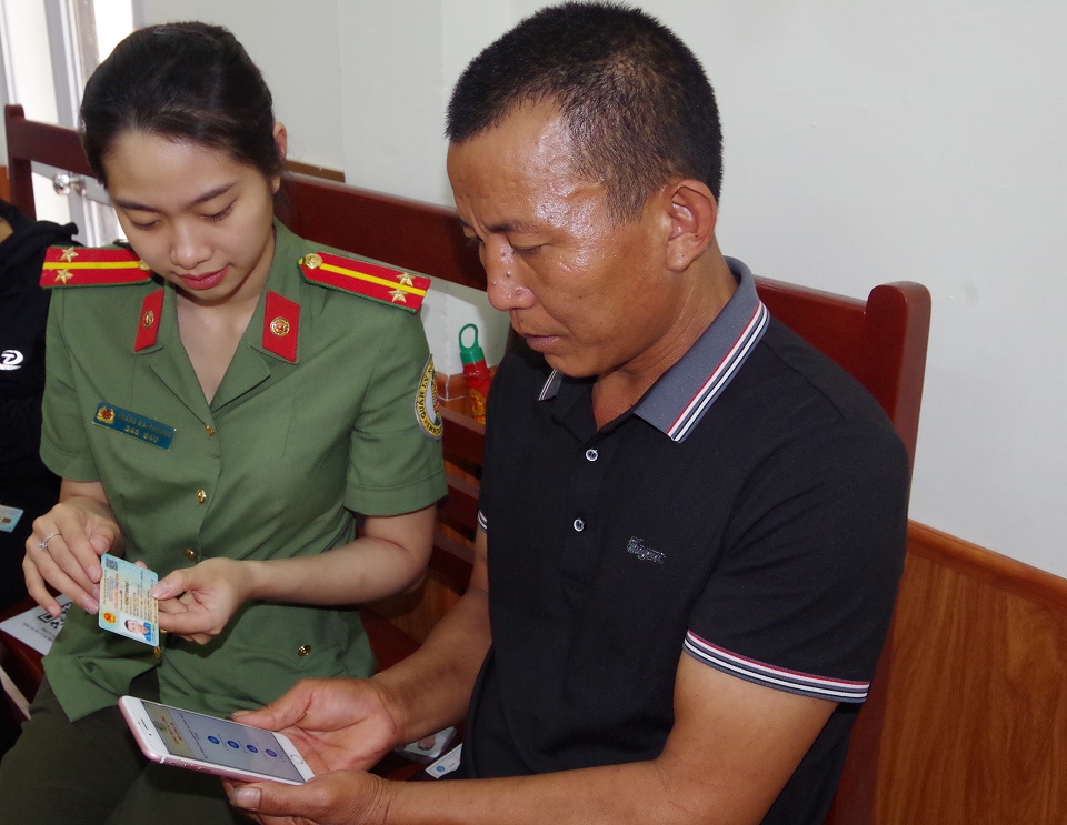 Cán bộ, chiến sĩ Phòng Quản lý xuất nhập cảnh, Công an tỉnh Hà Nam huớng dẫn người dân đăng ký dịch vụ công trực tuyến và nộp tiền qua mã QR (2)