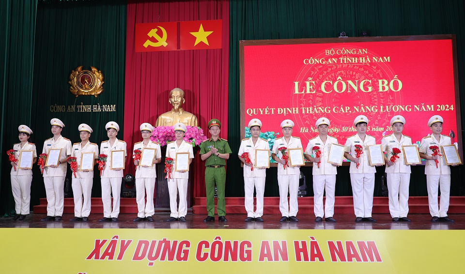 Đại tá Phạm Hùng Dương Uỷ viên BTV Đảng uỷ, Phó Giám đốc Công an tỉnh trao Quyết định và tặng hoa chúc mừng các đồng chí được thăng cấp bậc hàm, nâng bậc lương năm 2024